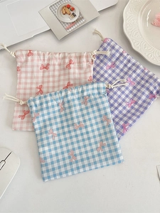 Three plaid drawstring storage bags with pink bow pattern in pink, blue, and purple