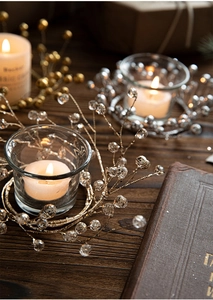 Detail of elegant champagne gold beaded candle holder with crystal glass cup for festive decor