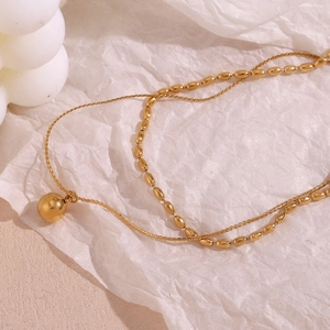 Detail of 18K gold plated double layer necklace with polished beads and ball pendant