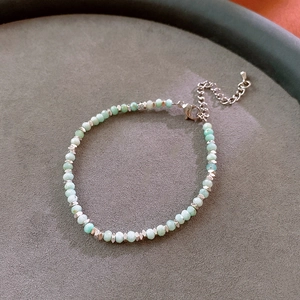 Detail of faceted mint green stone beads and silver spacers on a handmade bracelet