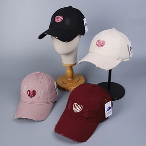 Détail de la broderie en cœur CUHU sur des casquettes de baseball en coton vieilli