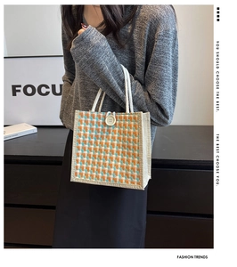 Detail of multi-color plaid linen tote bag with white rope handles and decorative button