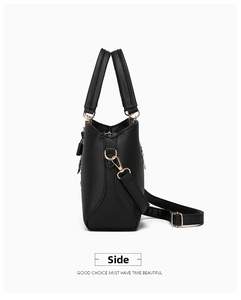 Side view of black lychee-grain leather tote bag with gold hardware and dual handles