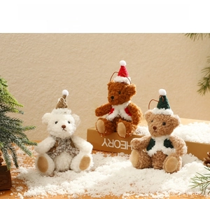 Detailed view of plush Christmas teddy bears in red vests on a snowy holiday backdrop