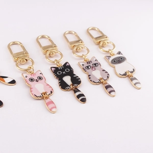 Five cute enamel cartoon cat keychains in different colors on a clean white background
