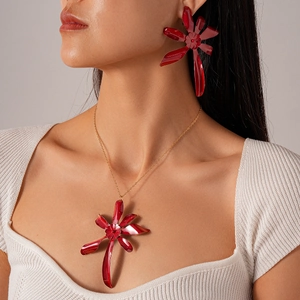 Close-up of vibrant red layered flower pendant and matching earrings set on model