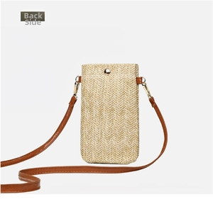 Detailed back view of a summer woven straw mobile phone bag with brown shoulder strap