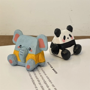 Détail de figurines d'éléphant et de panda en bois sculpté main sur un carnet de croquis