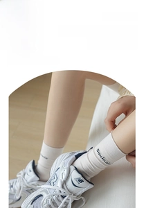 Close-up of white rib-knit crew socks paired with vintage-style mesh athletic sneakers