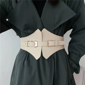 Detail of cream PU leather wide corset belt with double buckles on a green trench coat