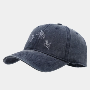 Détail de broderie d'oiseaux sur casquette en denim délavé vintage au fini vieilli