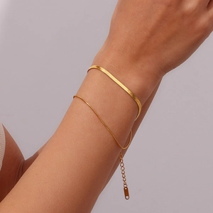 Close-up of a double-layered gold snake chain bracelet worn on a woman's wrist