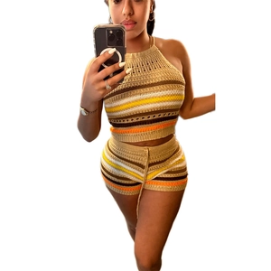 Dettaglio di un set top a lupetto in maglia e pantaloncini a righe su una modella