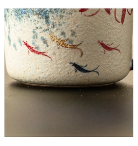 Macro shot of smooth polished ceramic base featuring hand-painted koi fish patterns