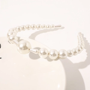 Detailed macro shot of white gradient pearls on a minimalist elegant thin headband