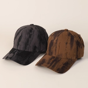 Close-up of vintage tie-dye baseball caps with distressed edges and oil-washed fabric