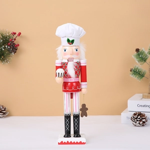 Close-up of wooden Christmas nutcracker chef with festive pine and ornaments decor