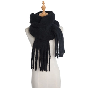 Thick black mohair scarf with tassels on a mannequin for winter warmth and style