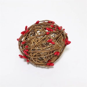 Détail d'une boule décorative en rotin avec baies rouges pour décoration de Noël DIY