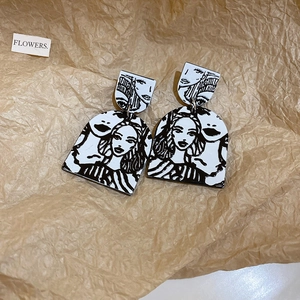 Artistic monochrome earrings with vintage comic face prints on a geometric arch design