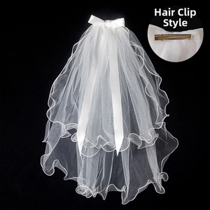 Short double-layer bridal veil with satin bow and metal hair clip detail for weddings