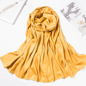 Detailed texture of golden matte satin silk scarf with soft drape and glossy finish