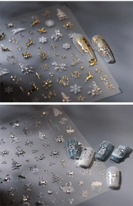 Detail of Christmas nail stickers featuring gold reindeer and snowflake patterns