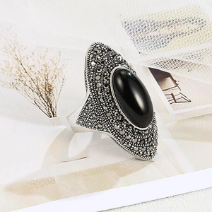 Macro detail of vintage bohemian ring with black oval stone and antique silver texture