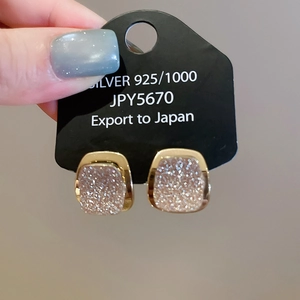 Close-up of 18k gold plated 925 silver square earrings with sparkling pink center glitter
