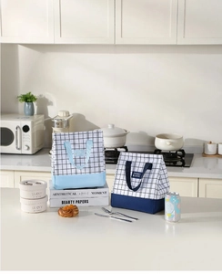Close-up of stylish plaid thermal lunch bags with durable handles and secure brand labels