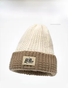 Dettaglio della trama a nido d'ape e etichetta in tessuto su un berretto invernale beige