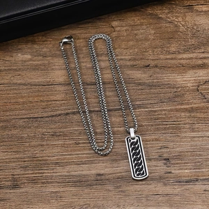 Detail of square stainless steel pendant with black oil drip stripe on a box chain