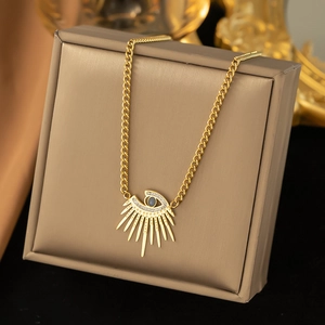 Detailed shot of a gold evil eye necklace with blue stone on a beige jewelry box