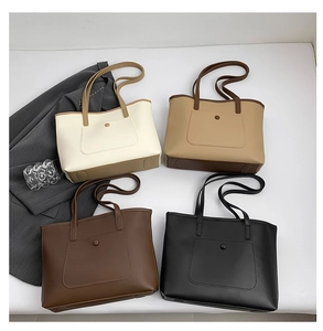 Vista piatta di grandi borse tote minimaliste nei colori crema, kaki, marrone e nero