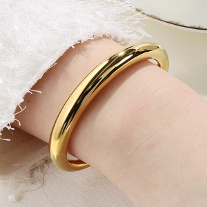 Bracelet jonc en C en acier inoxydable plaqué or 18k présenté sur le poignet du mannequin