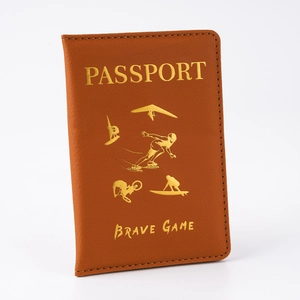 Detail of vintage brown PU leather passport holder with gold-stamped sports icons