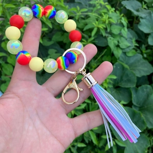 Close-up of colorful silicone beaded bracelet with blue leather tassel and gold clasp