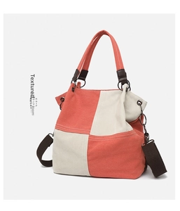 Detail of canvas tote featuring contrast stitching and detachable brown woven shoulder strap