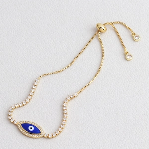 Detail of gold Evil Eye bracelet with blue enamel, zircon stones and adjustable slider clasp