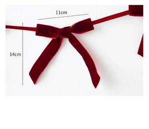 Detail view of red velvet bow decoration with dimensions of 11cm by 14cm