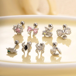 Surgical steel cartilage studs featuring pink heart bow and black spider crystal designs