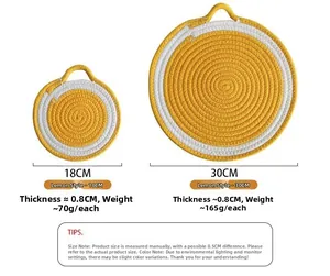 Close-up of circular woven cotton placemats with yellow spiral design and hanging loops