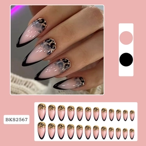 Detail of stiletto press-on nails featuring nude pink base, black tips and gold leopard print