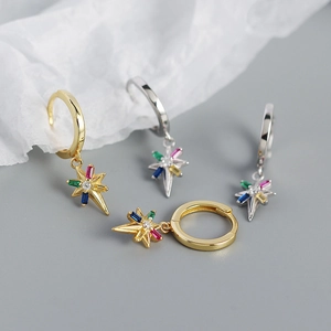 Detail showing gold and silver starburst earrings with multi-color gemstone pendants