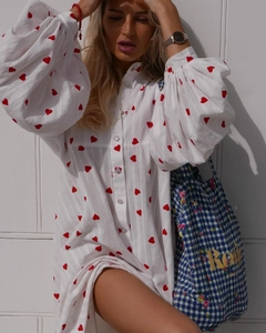 Détail de la robe en coton blanc avec imprimés cœurs rouges et manches lanternes