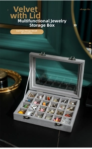Grey velvet jewelry box with glass lid showing multi-slot storage for rings and earrings