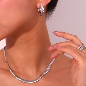 Detail of silver jewelry set with fishbone pattern and zircon inlays on model