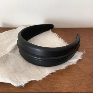 Elegant black faux leather padded headband for women with a minimalist high-top design