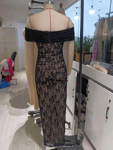 Detail of elegant black lace evening dress showing the back zipper and floral pattern