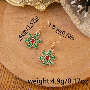 Detail of Christmas snowflake drop earrings with green enamel and red crystal inlay